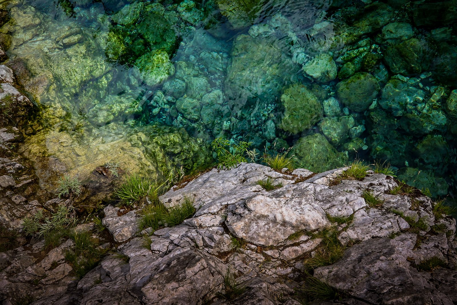 Clear water over mossy stones and pale rock