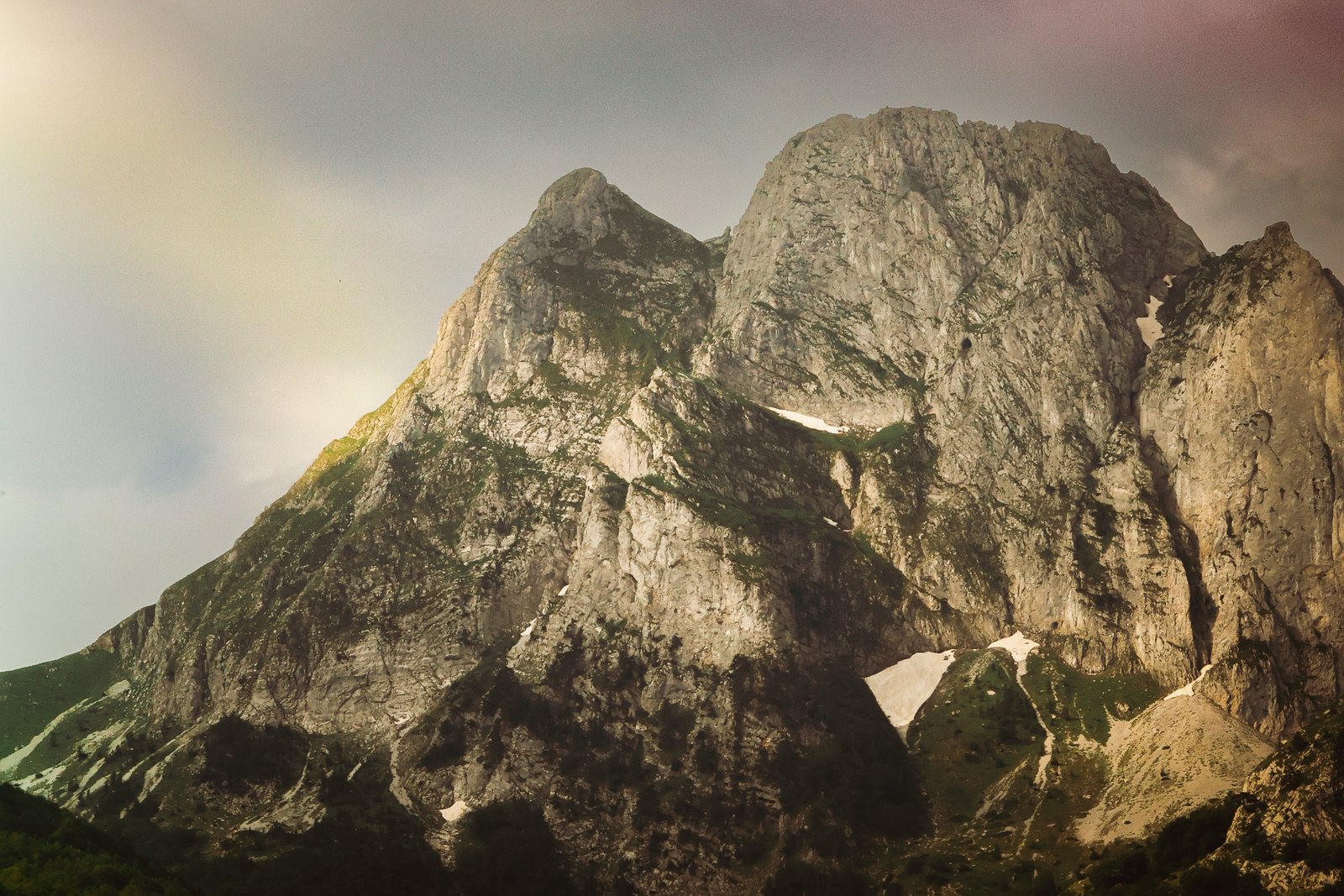 A pale limestone peak with a snow patch