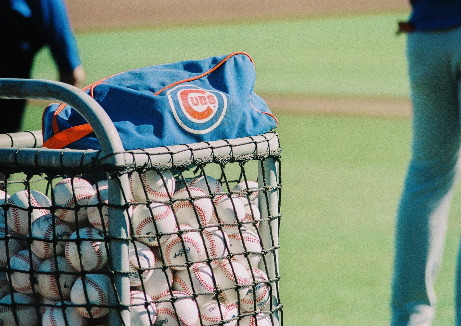 A ball cart with a Cubs bag on the field