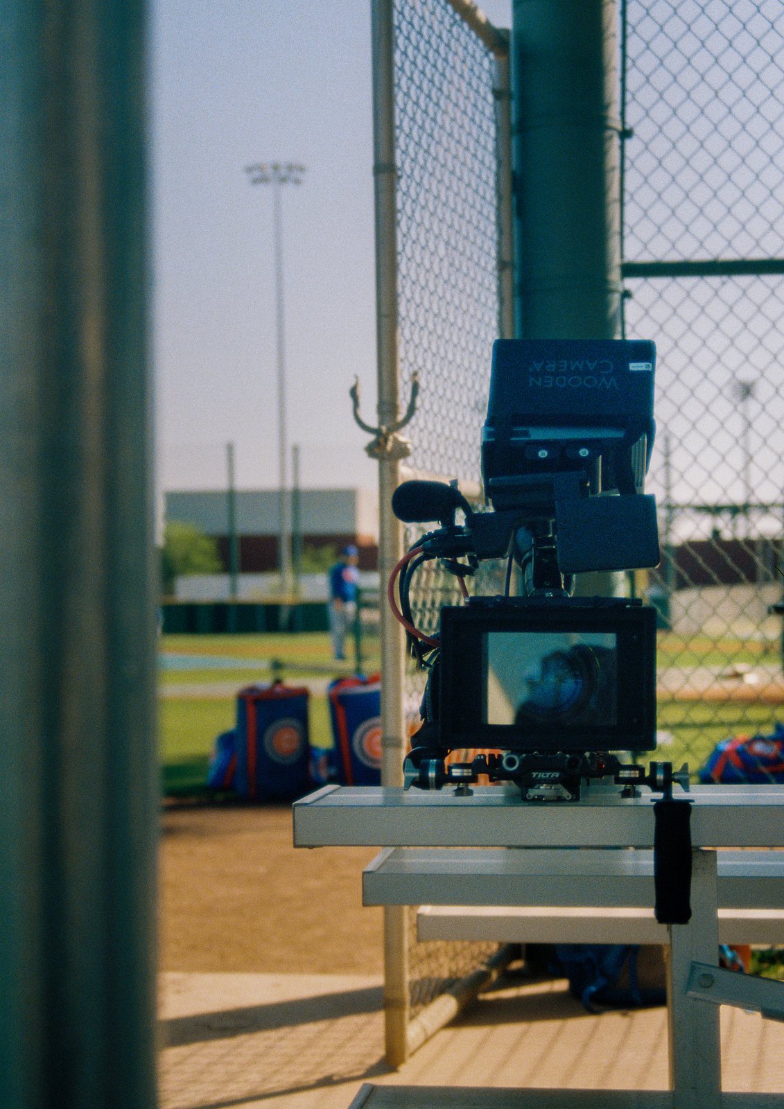 A cinema camera set on a dugout bench