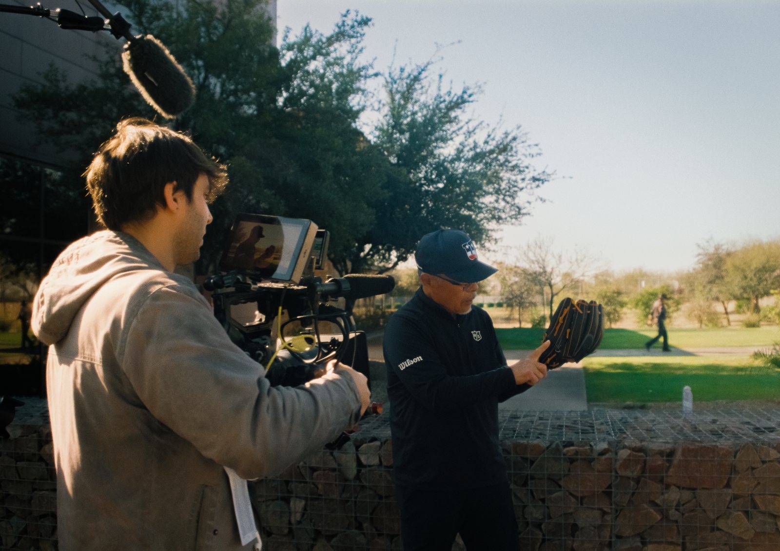 A camera operator films a glove craftsman