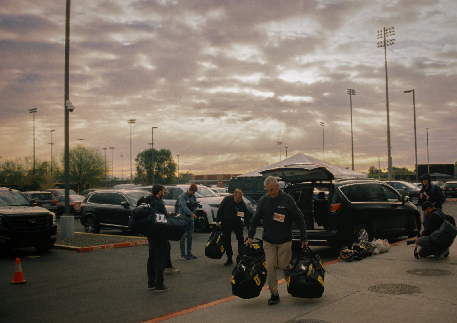 Crew carrying equipment bags at sunrise