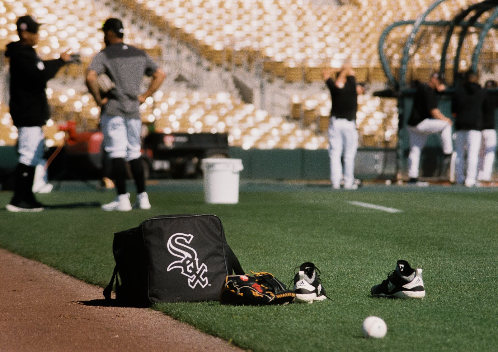 A team bag, glove and cleats on the grass