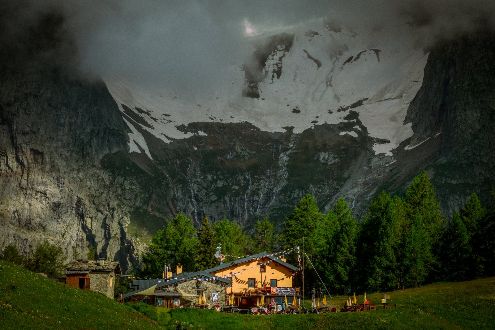 A mountain hut below a hanging glacier
