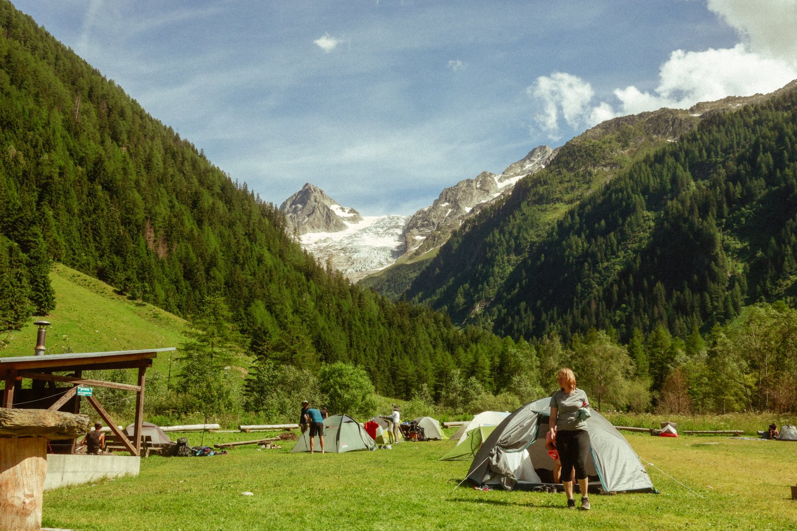 Tents pitched in a green valley campsite