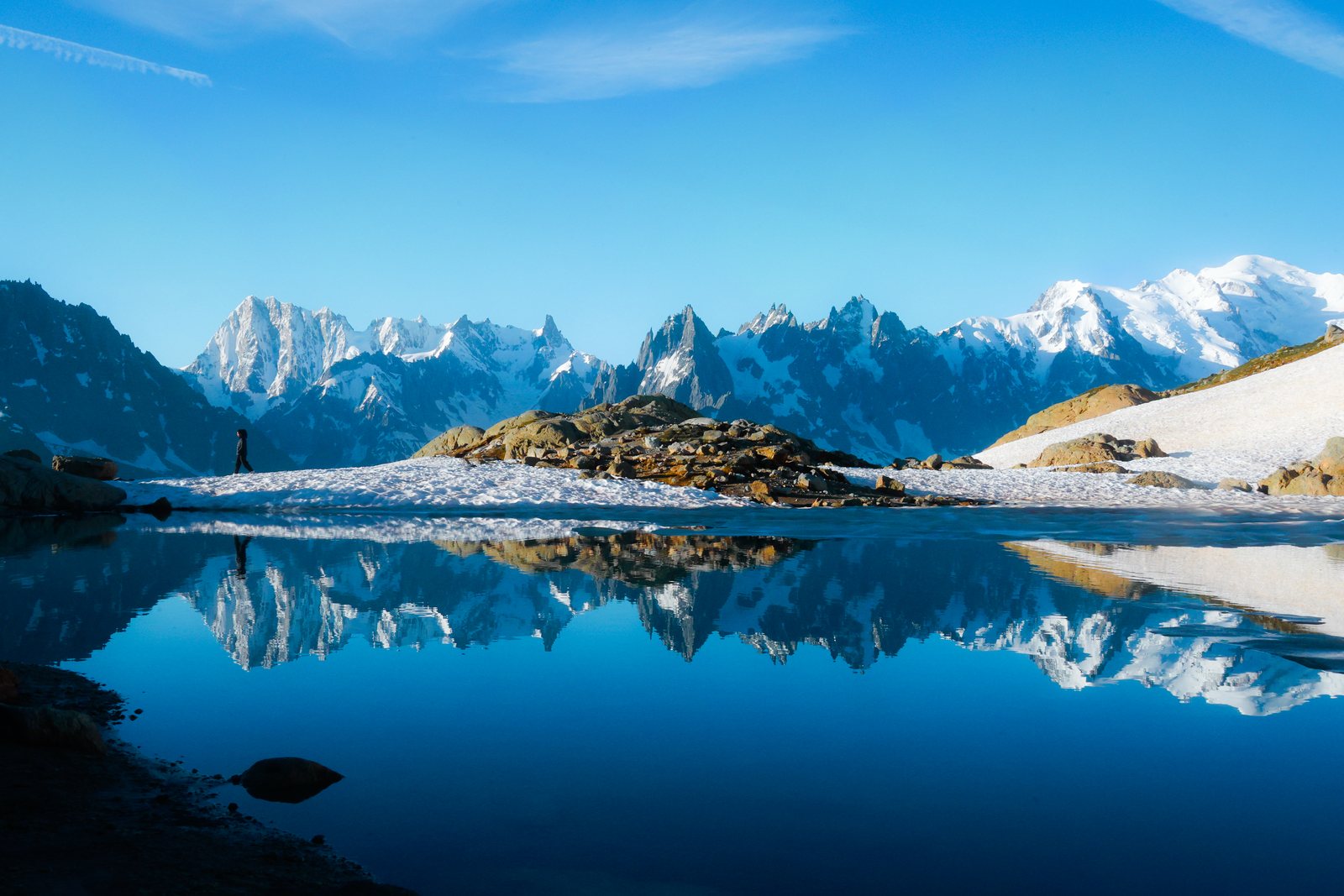 Snowy peaks reflected in a deep blue alpine lake