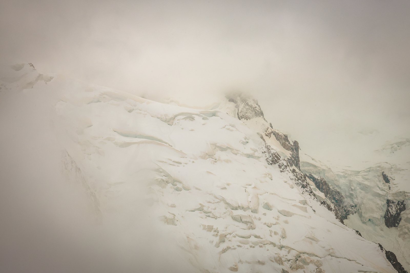 A snowy mountainside fading into fog