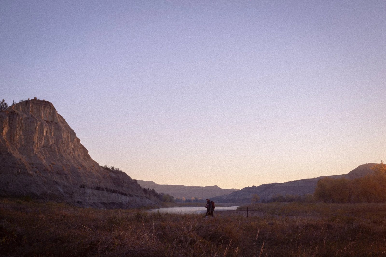 Pale bluffs above a quiet river at dusk