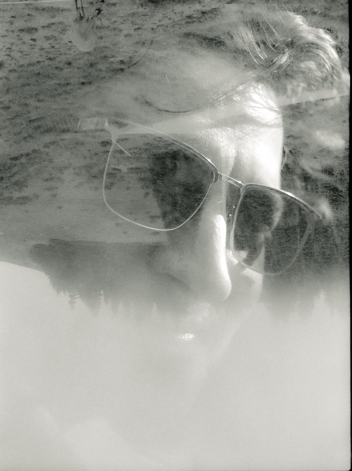 Black and white double exposure of a face in sunglasses