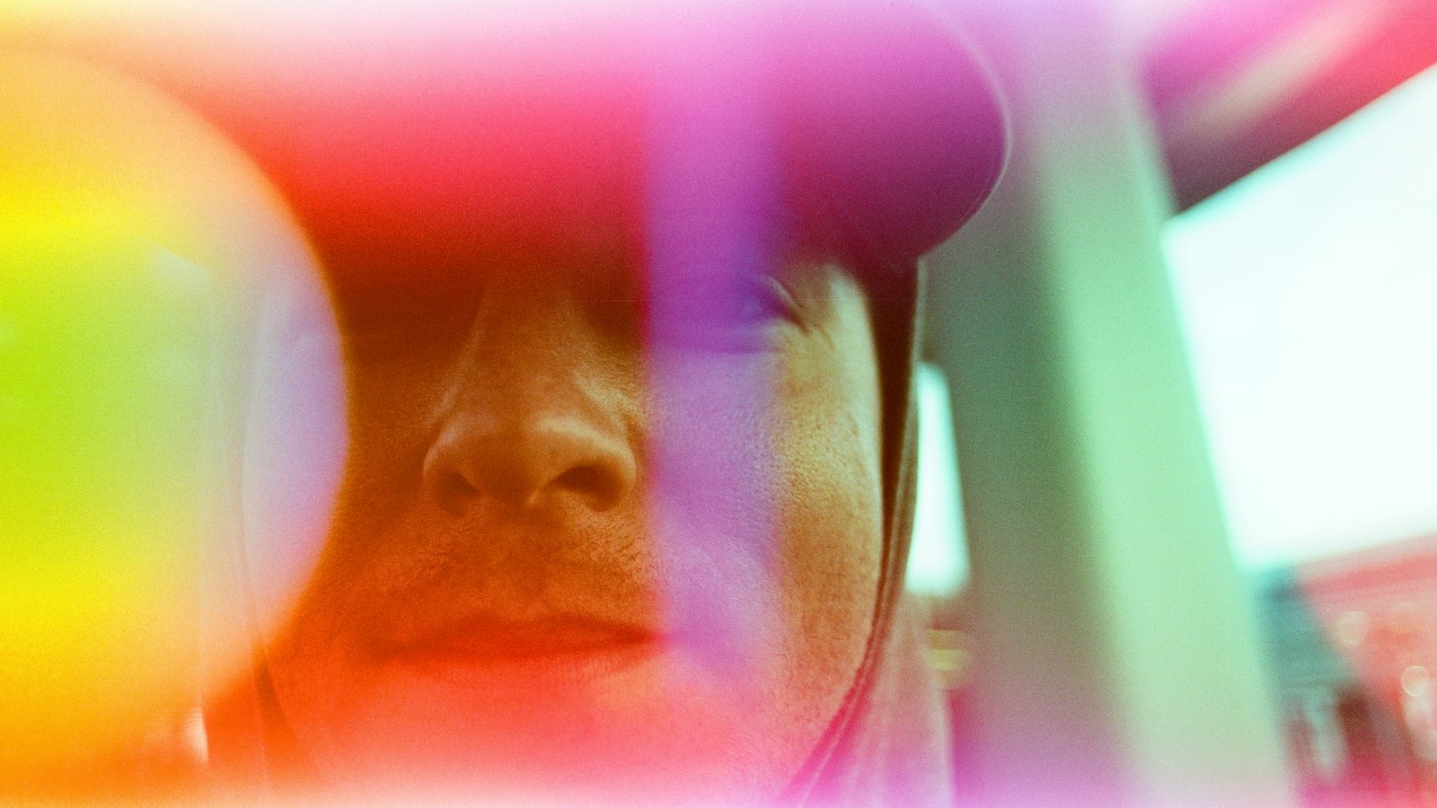 A face glowing through rainbow film light